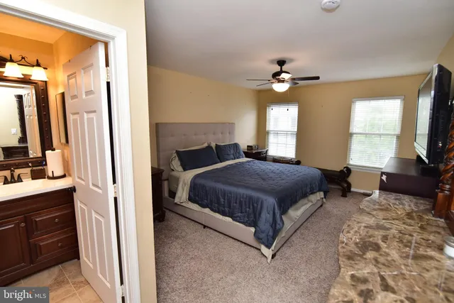 a bedroom with a large bed a flat tv screen and a dresser