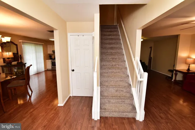 a view of a hallway with wooden floor and stairs