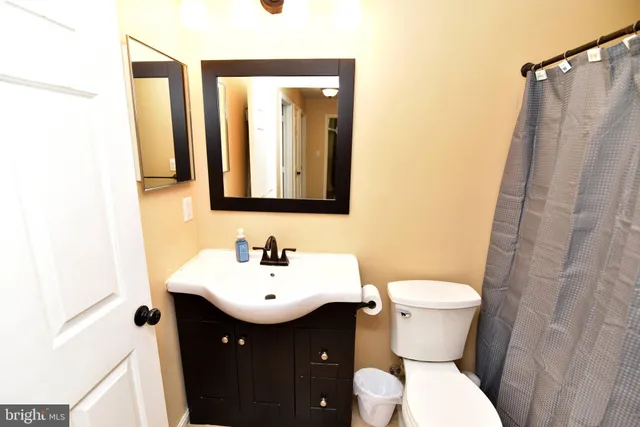 a bathroom with a sink and mirror with toilet