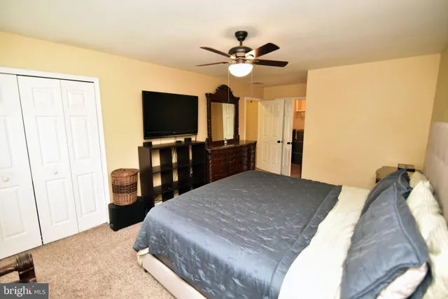 a bedroom with a bed and a flat tv screen on dresser