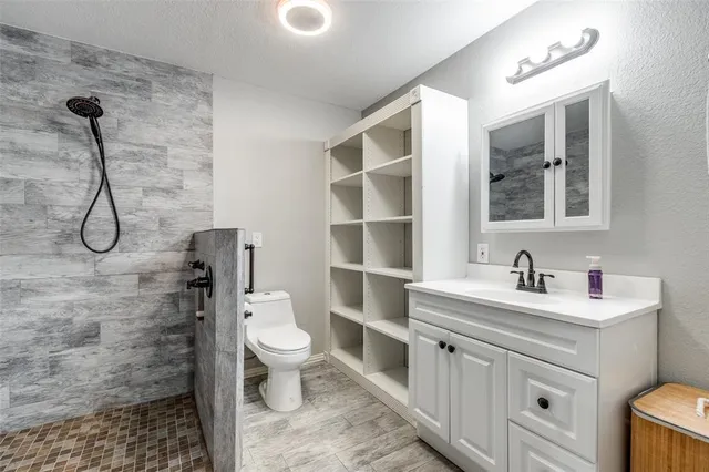 a bathroom with a granite countertop toilet sink and mirror