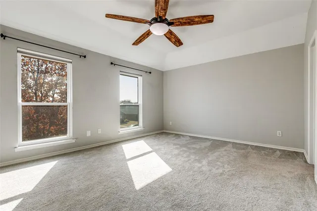 an empty room with windows and fan