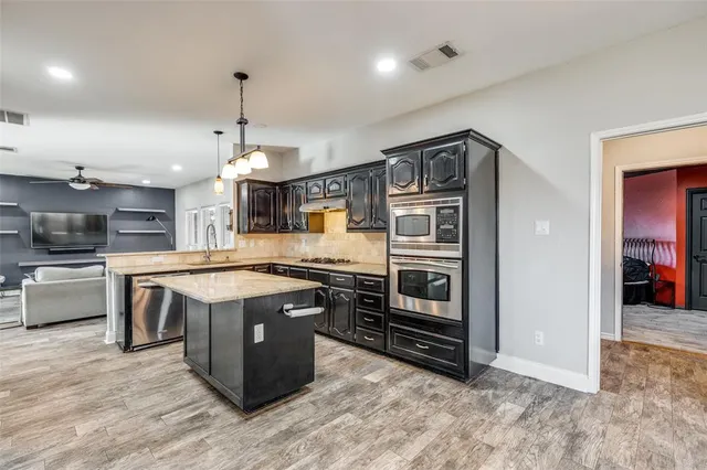 a kitchen with stainless steel appliances granite countertop a stove and a refrigerator