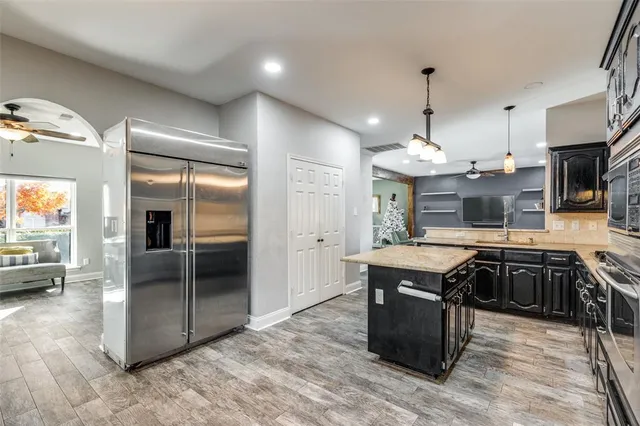 a kitchen with stainless steel appliances granite countertop a sink a stove and a refrigerator