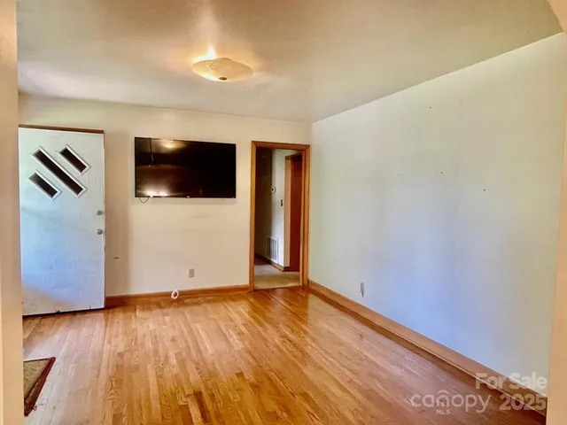 a view of a livingroom with wooden floor and a flat screen tv