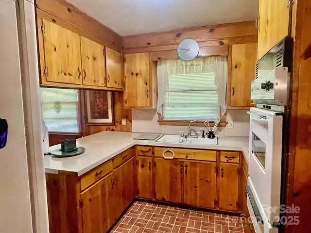 a kitchen with stainless steel appliances a stove a sink and a cabinets