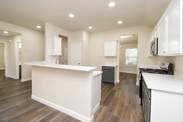 a kitchen with sink cabinets and wooden floor