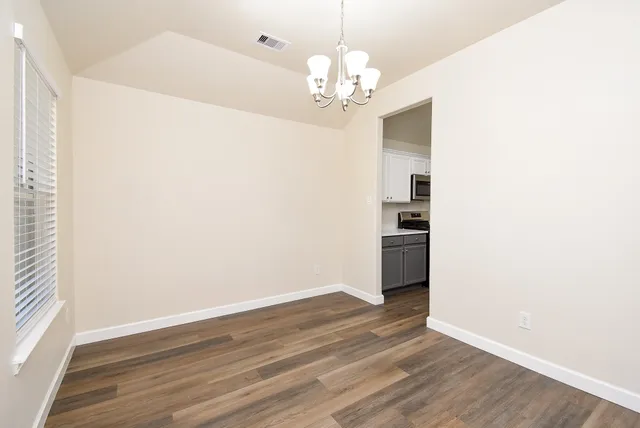 a view of a livingroom with wooden floor and a large window