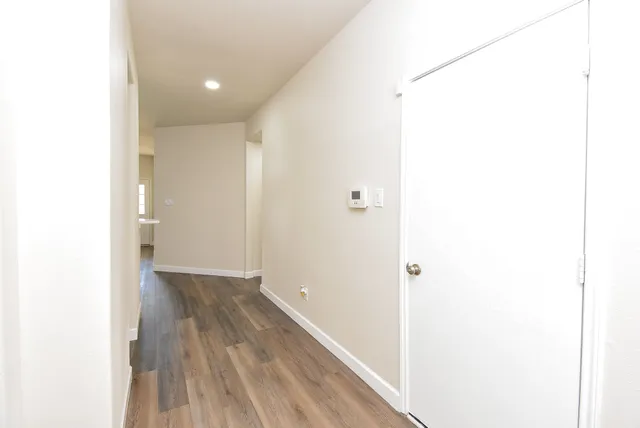 a large kitchen with stainless steel appliances a large counter top a stove and a wooden floors