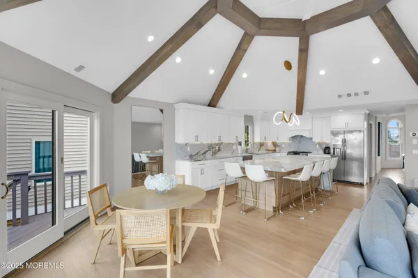 a dining room with stainless steel appliances kitchen island a table and chairs