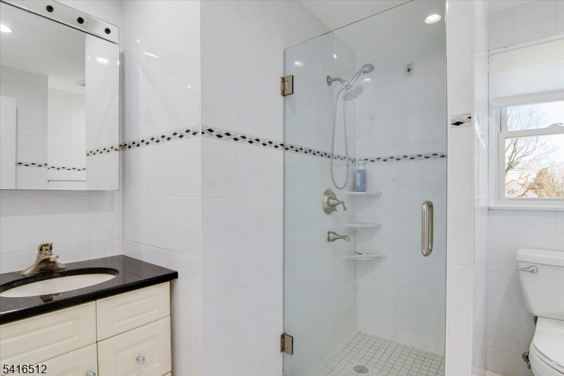 565 Center Street Wood-Ridge, NJ 07075 - Photo 13 of 26 a bathroom with a granite countertop sink a toilet and shower