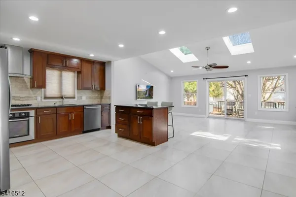 a large kitchen with kitchen island granite countertop a stove a sink dishwasher and a refrigerator