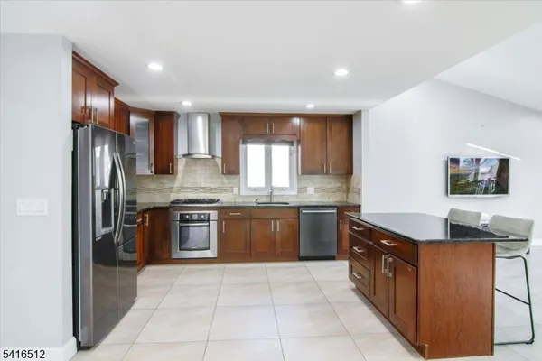 a kitchen with stainless steel appliances granite countertop a refrigerator and a stove top oven
