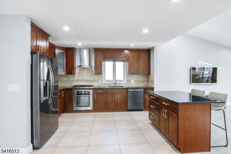 565 Center Street Wood-Ridge, NJ 07075 - Photo 4 of 26 a kitchen with stainless steel appliances granite countertop a refrigerator and a stove top oven