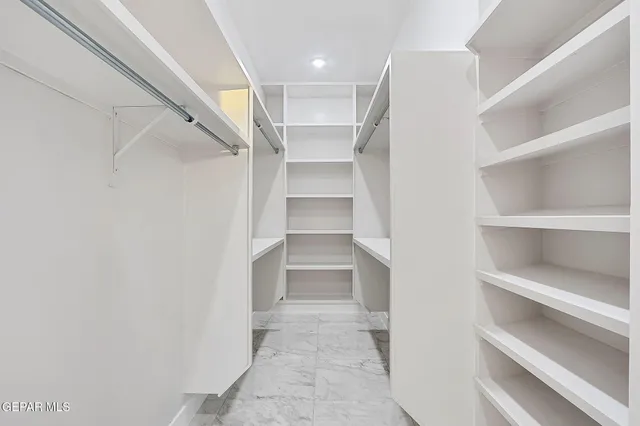 a view of walk in closet with empty racks