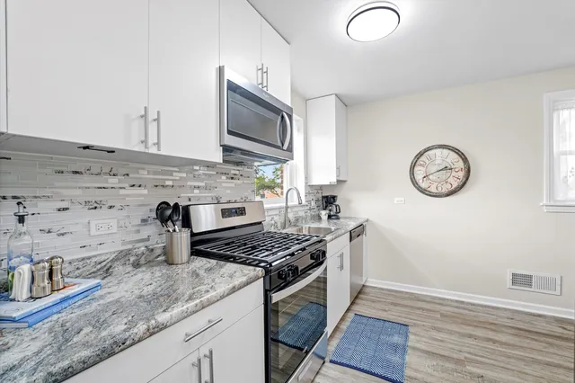 a kitchen with granite countertop a stove and a microwave