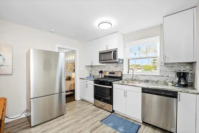 a kitchen with a refrigerator stove microwave and sink