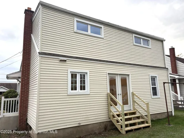 a view of a white house with a yard and furniture