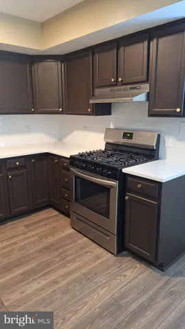 a kitchen with wooden cabinets and a stove top oven