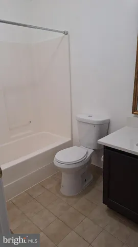 a white toilet sitting next to a bath tub and a shower