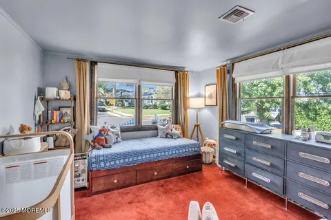 a bedroom with a bed and large windows