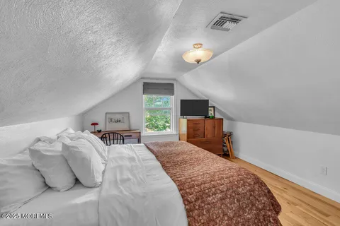 a spacious bedroom with a bed and large windows