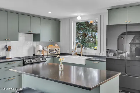 a kitchen with kitchen island granite countertop a sink a stove and wooden cabinets