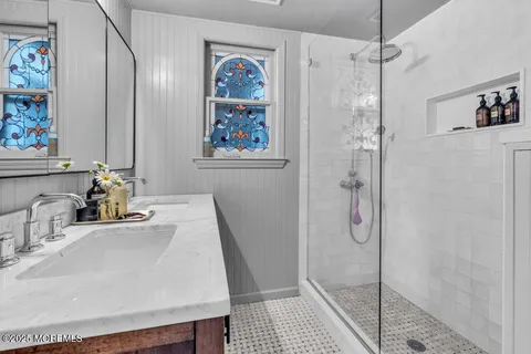 a bathroom with a sink a mirror and a shower