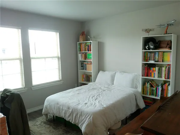 a bedroom with a bed a dresser and a book shelf