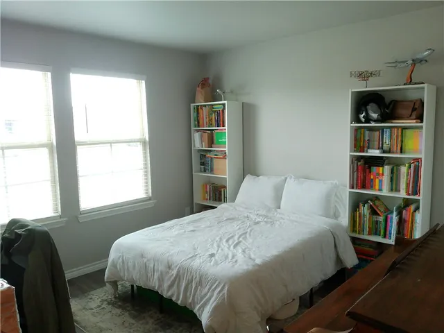 a bedroom with a bed a dresser and a book shelf