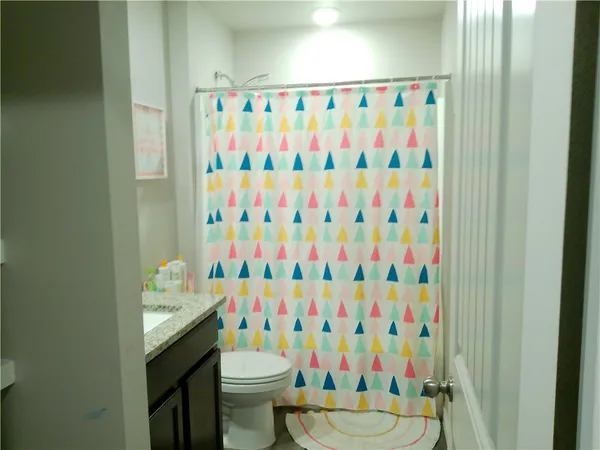 a bathroom with a sink toilet and shower curtain