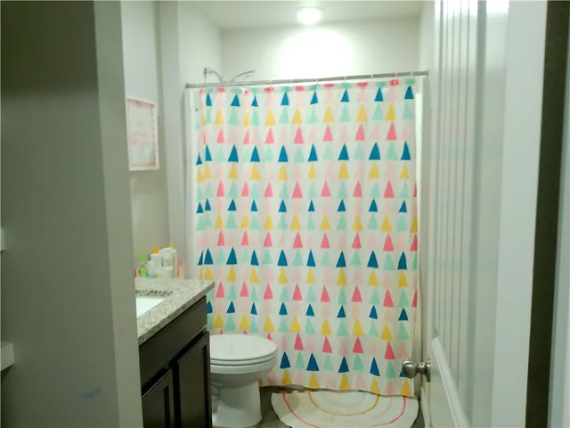 a bathroom with a sink toilet and shower curtain
