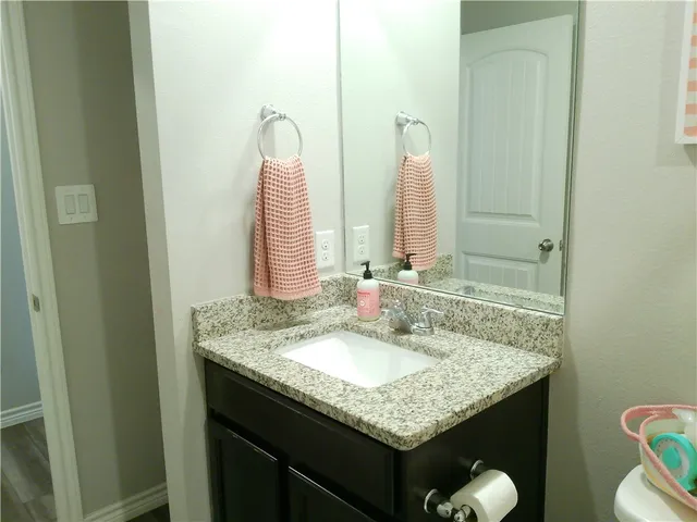 a bathroom with a granite countertop sink and a mirror