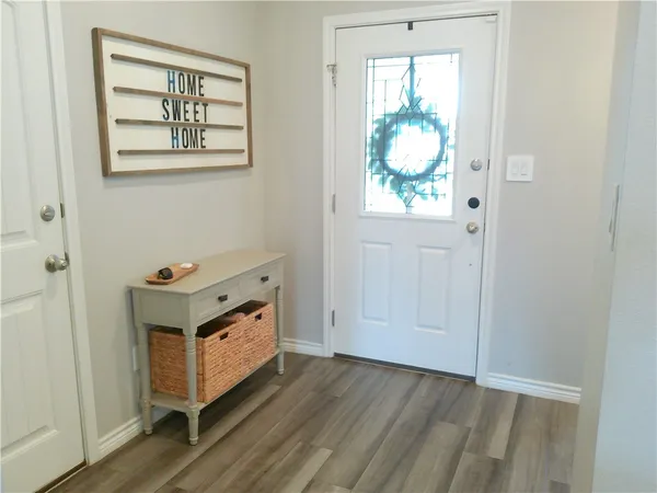 an entryway with wooden floor and windows