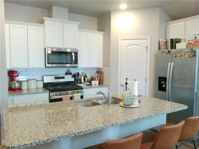 a kitchen with appliances a sink and cabinets