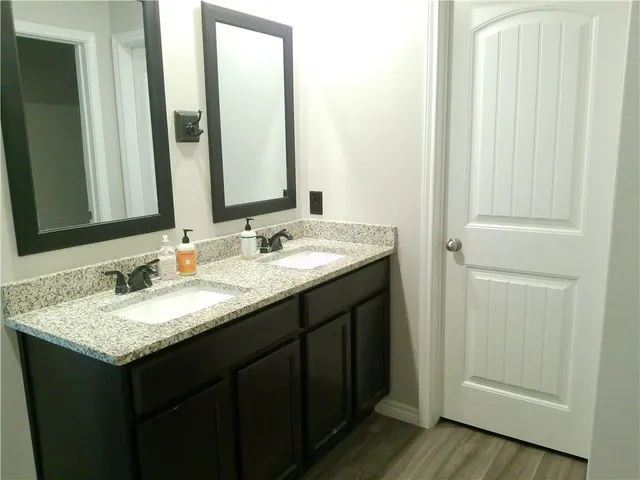 a bathroom with a granite countertop sink and a mirror