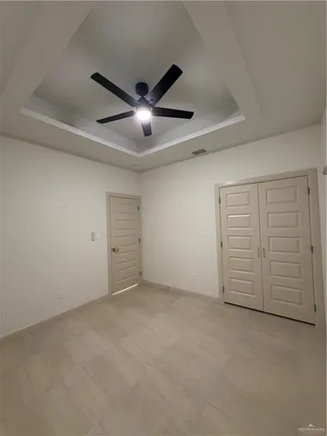 an empty room with closet and fan