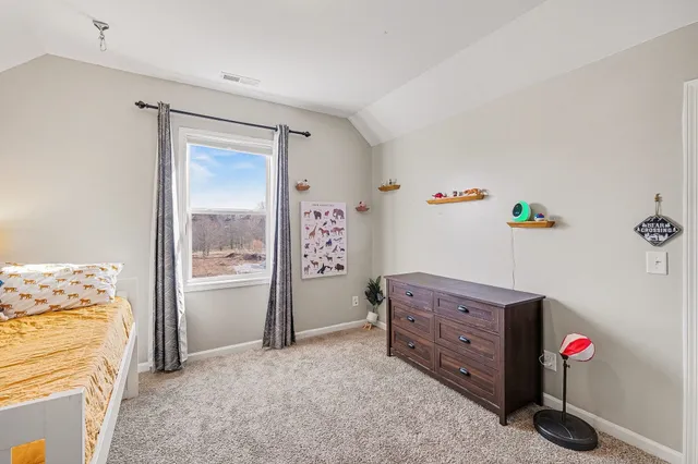 a view of a bedroom with baby bed and cabinet