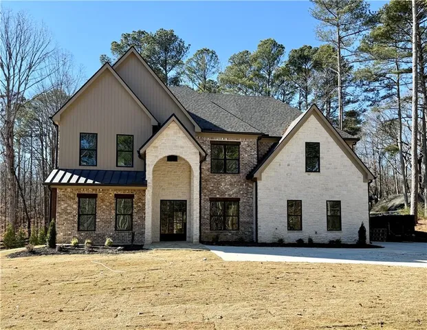 a view of a white house with a large tree with yard and large trees