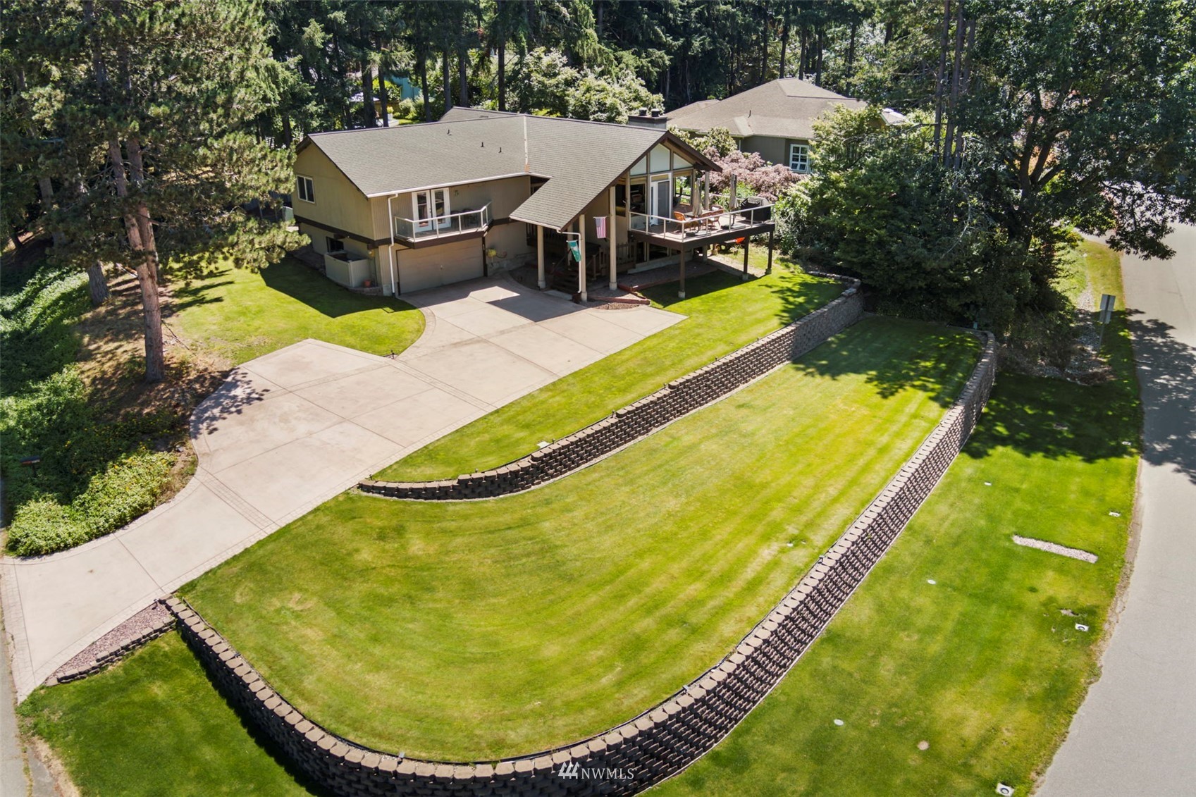 an aerial view of a house with swimming pool and trees