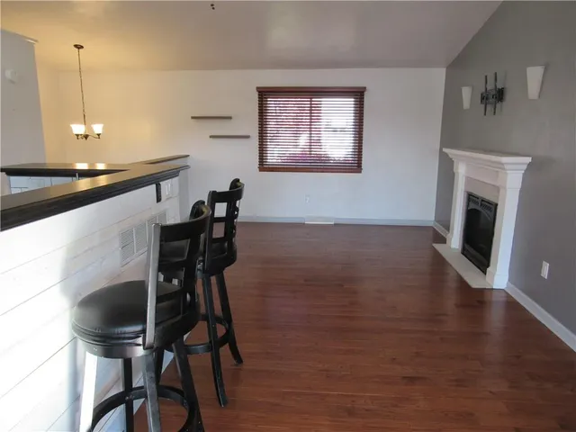 a kitchen with stainless steel appliances kitchen island hardwood floor and a window