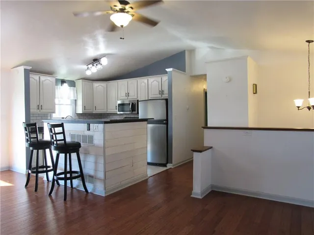 a kitchen with a table chairs refrigerator and microwave