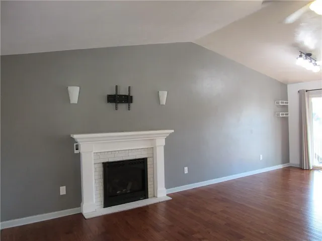 a living room with a fireplace and wooden floor