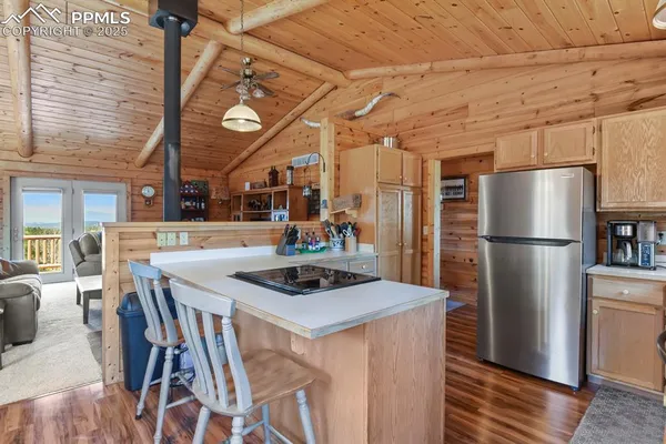 a kitchen with stainless steel appliances granite countertop a table chairs and a refrigerator