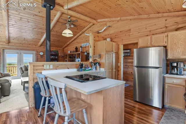 a kitchen with stainless steel appliances granite countertop a table chairs and a refrigerator