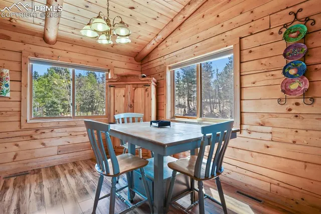 a view of a dining room with furniture large windows and wooden floor
