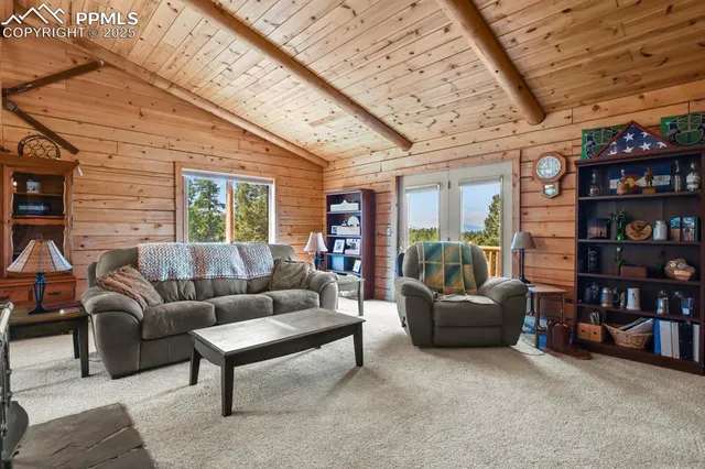 a living room with furniture a bookshelf and a large window