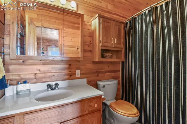 a bathroom with a granite countertop toilet sink and mirror