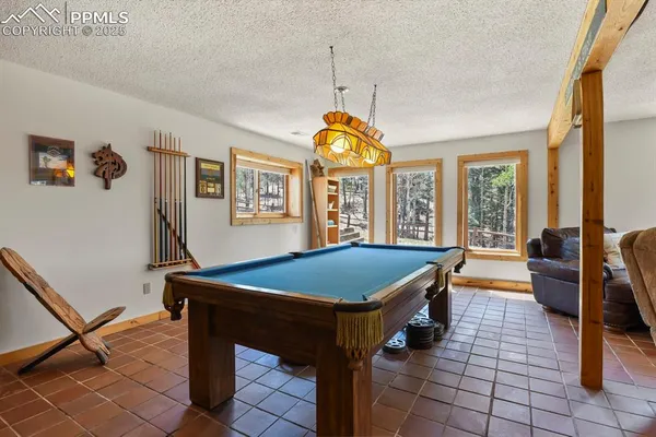 a living room with a table chairs and a chandelier