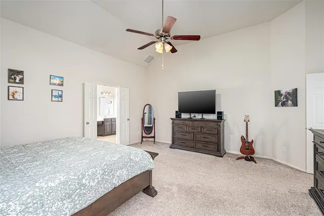 a spacious bedroom with a bed and chair